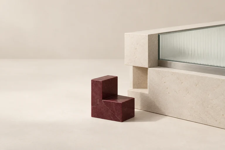 A separate burgundy corner piece sits beside a matching gap in a stone structure.