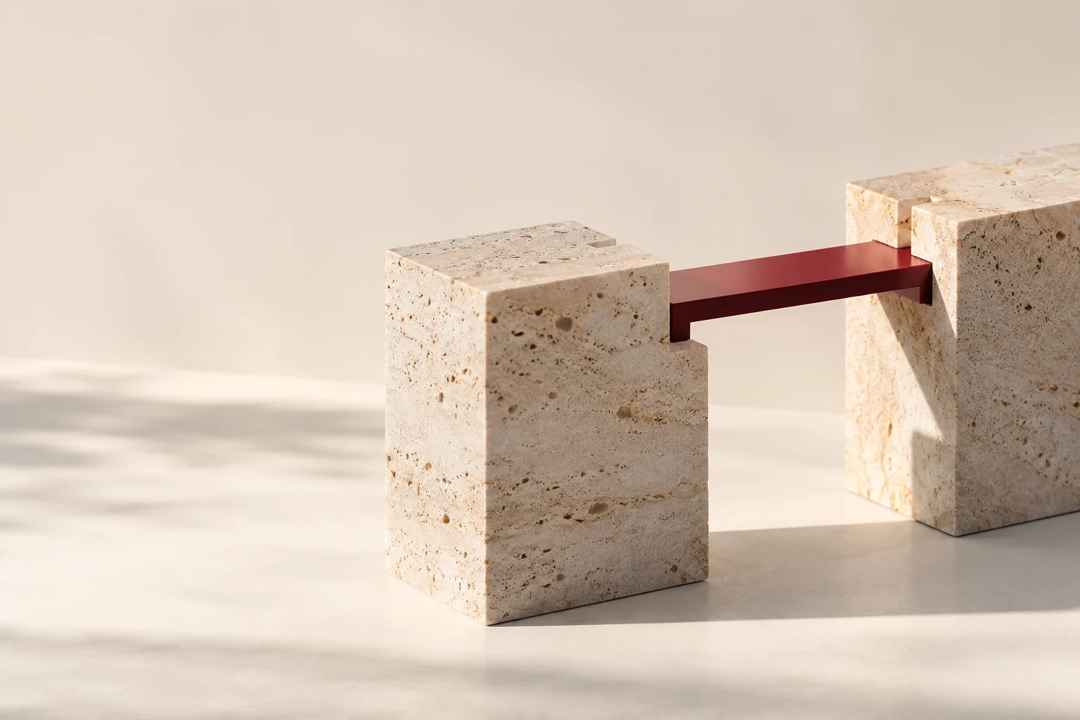 Two self-supporting stone structures joined by a slim burgundy removable connection.