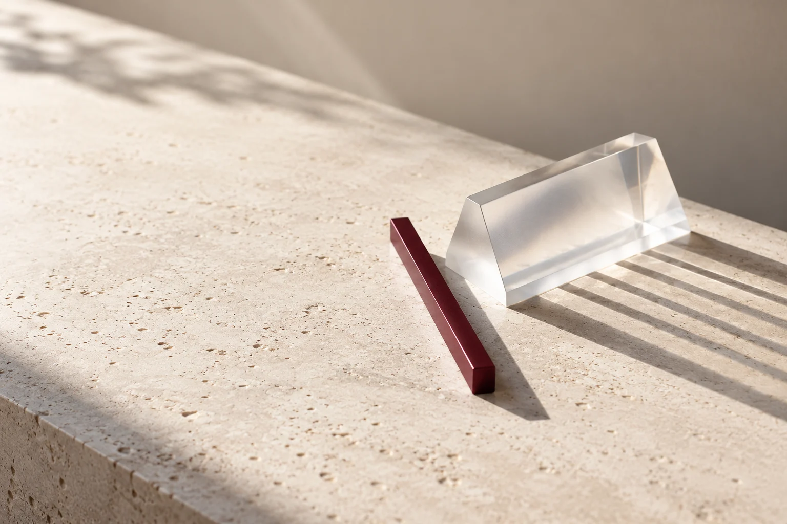 A frosted-glass prism and burgundy reference bar casting aligned shadows.