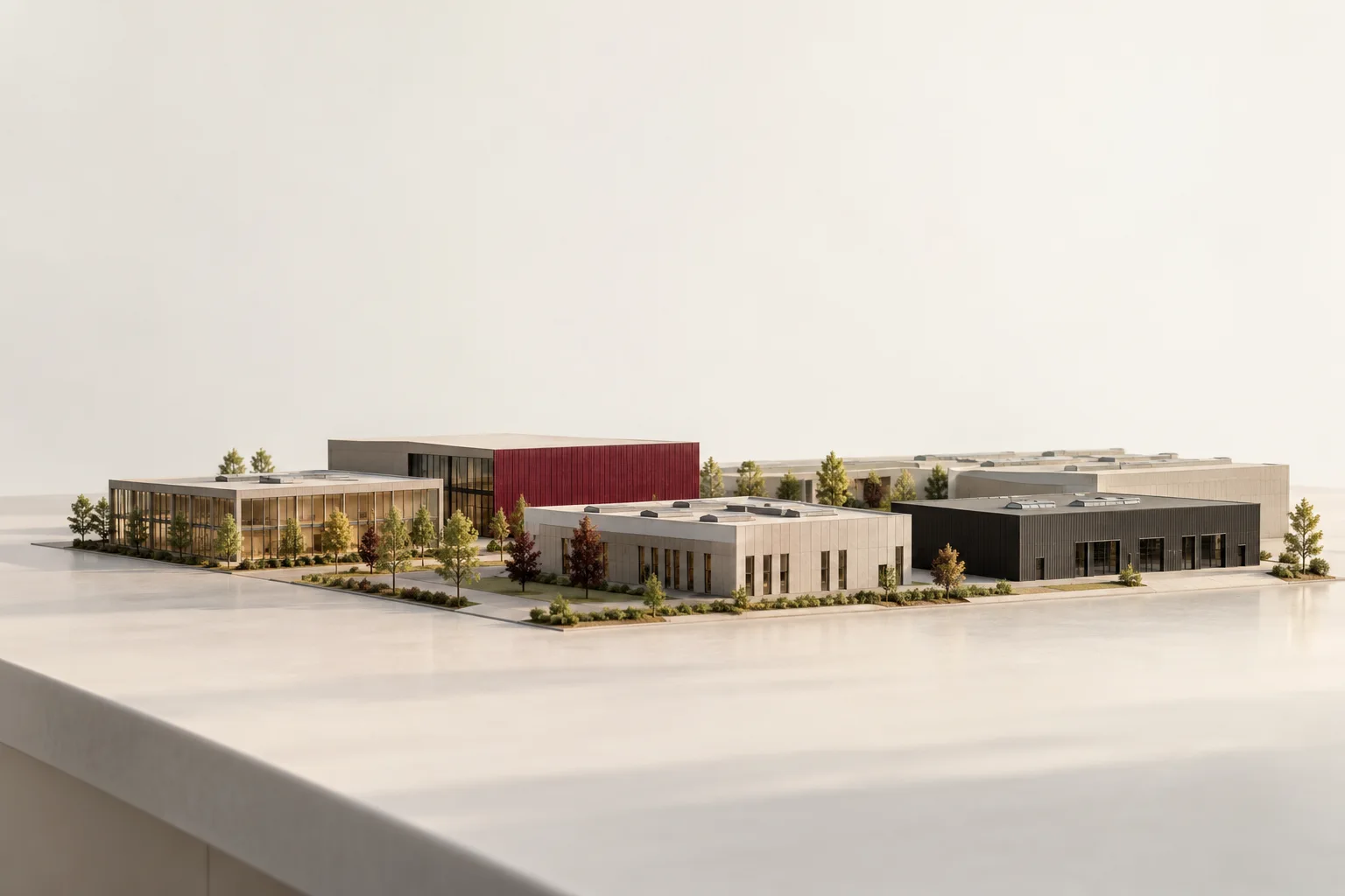 A physical architectural model of commercial and industrial buildings with one burgundy facade.
